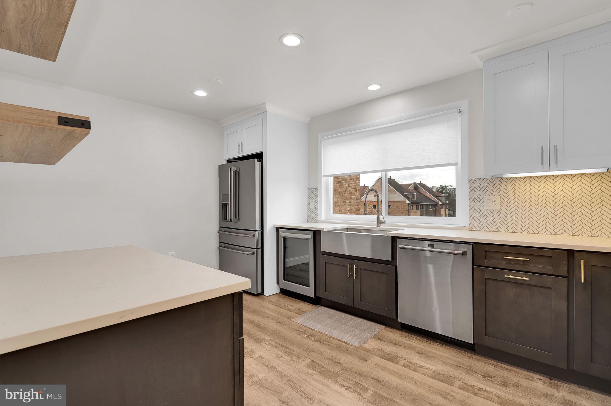 11514 Bucknell Drive, Unit 202 Silver Spring, MD 20902 - Photo 7 of 31 a kitchen with stainless steel appliances granite countertop a refrigerator a sink dishwasher a stove and white countertops with wooden floor
