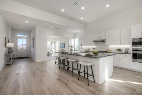 a kitchen with stainless steel appliances granite countertop a table chairs sink refrigerator and cabinets