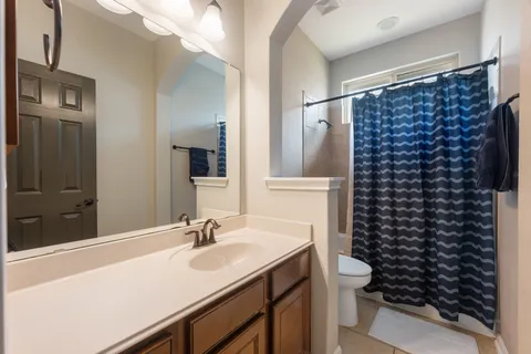 a bathroom with a sink a toilet a shower and a mirror