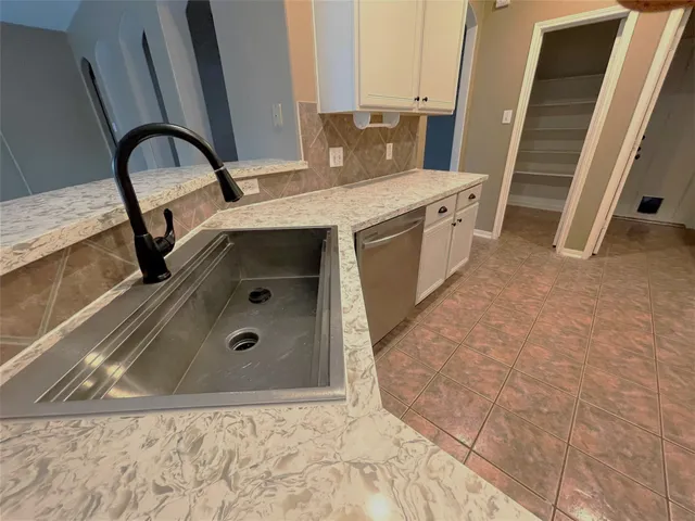 a bathroom with a granite countertop sink a toilet and a tub