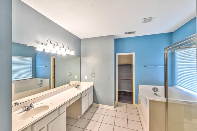 a spacious bathroom with a bathtub sink and mirror