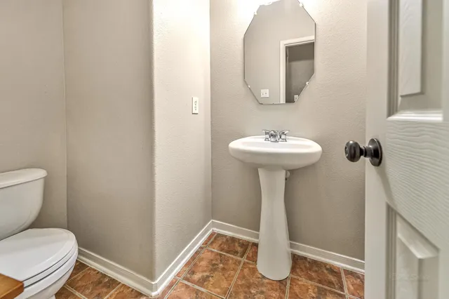 a bathroom with a toilet sink and mirror