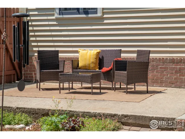 a view of a white house with a small yard and wooden fence