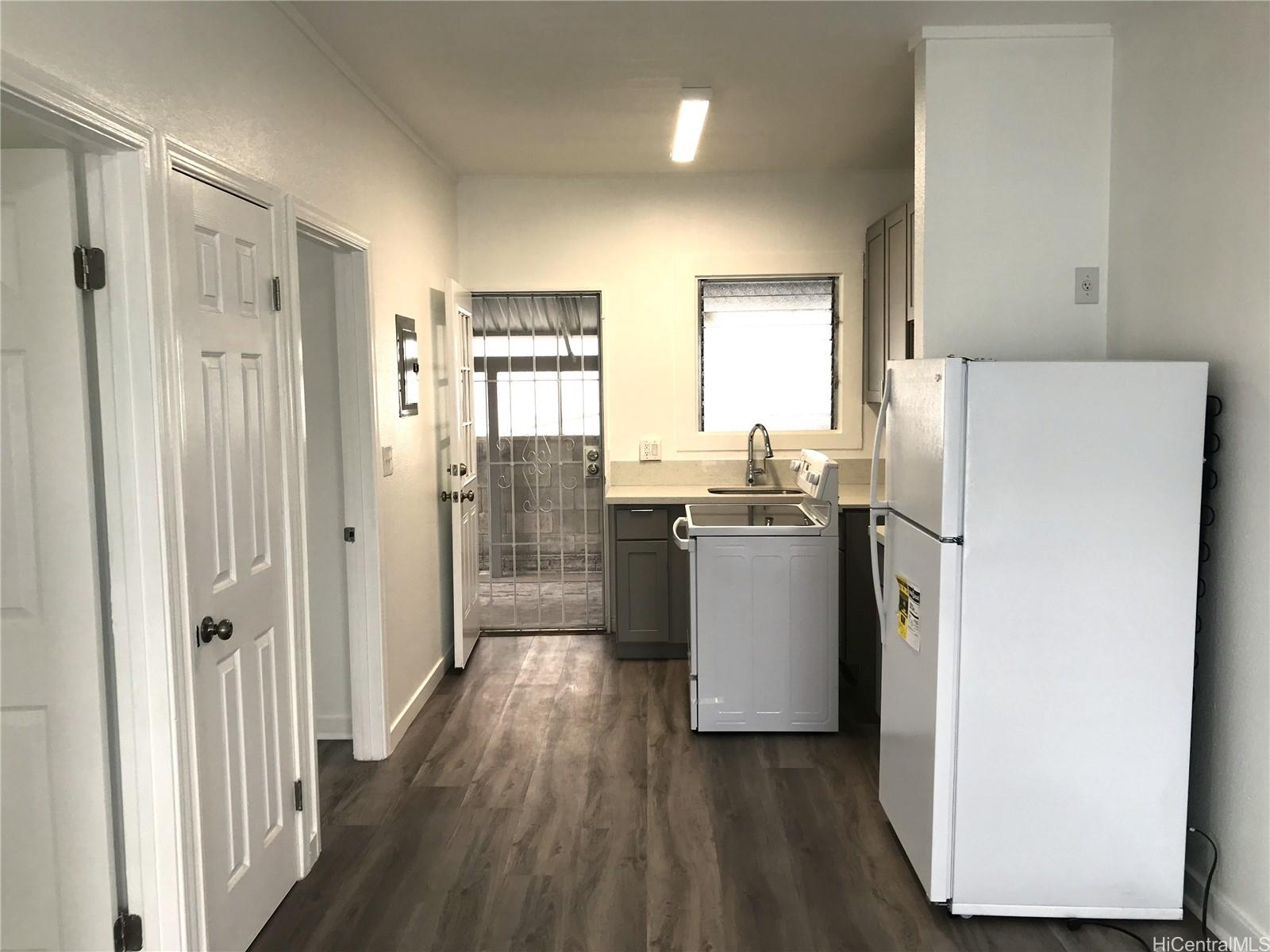1768 Silva Street Honolulu, HI 96819 - Photo 18 of 22 a kitchen with a refrigerator a sink and dishwasher with wooden floor