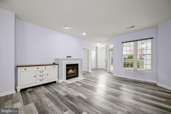 a view of an empty room with a fireplace and a window