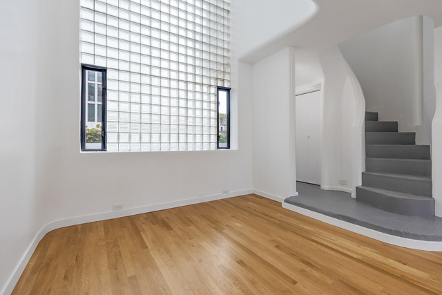 1209 North State Street, Unit 11 Chicago, IL 60611 - Photo 5 of 11 a view of an empty room with wooden floor and a window