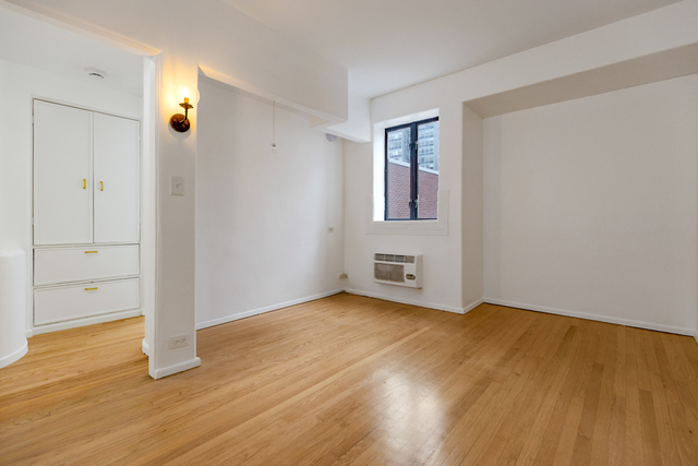 1209 North State Street, Unit 11 Chicago, IL 60611 - Photo 8 of 11 an empty room with wooden floor and windows