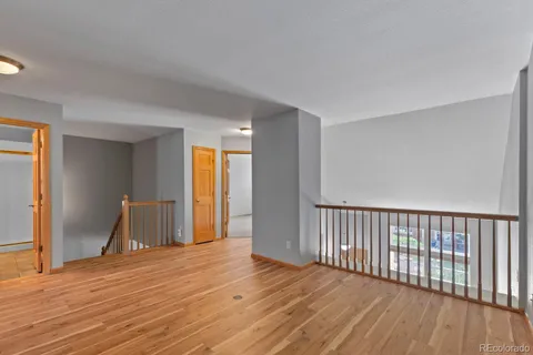a view of empty room with wooden floor