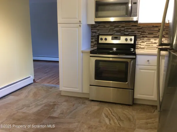 a kitchen with granite countertop a stove and a microwave