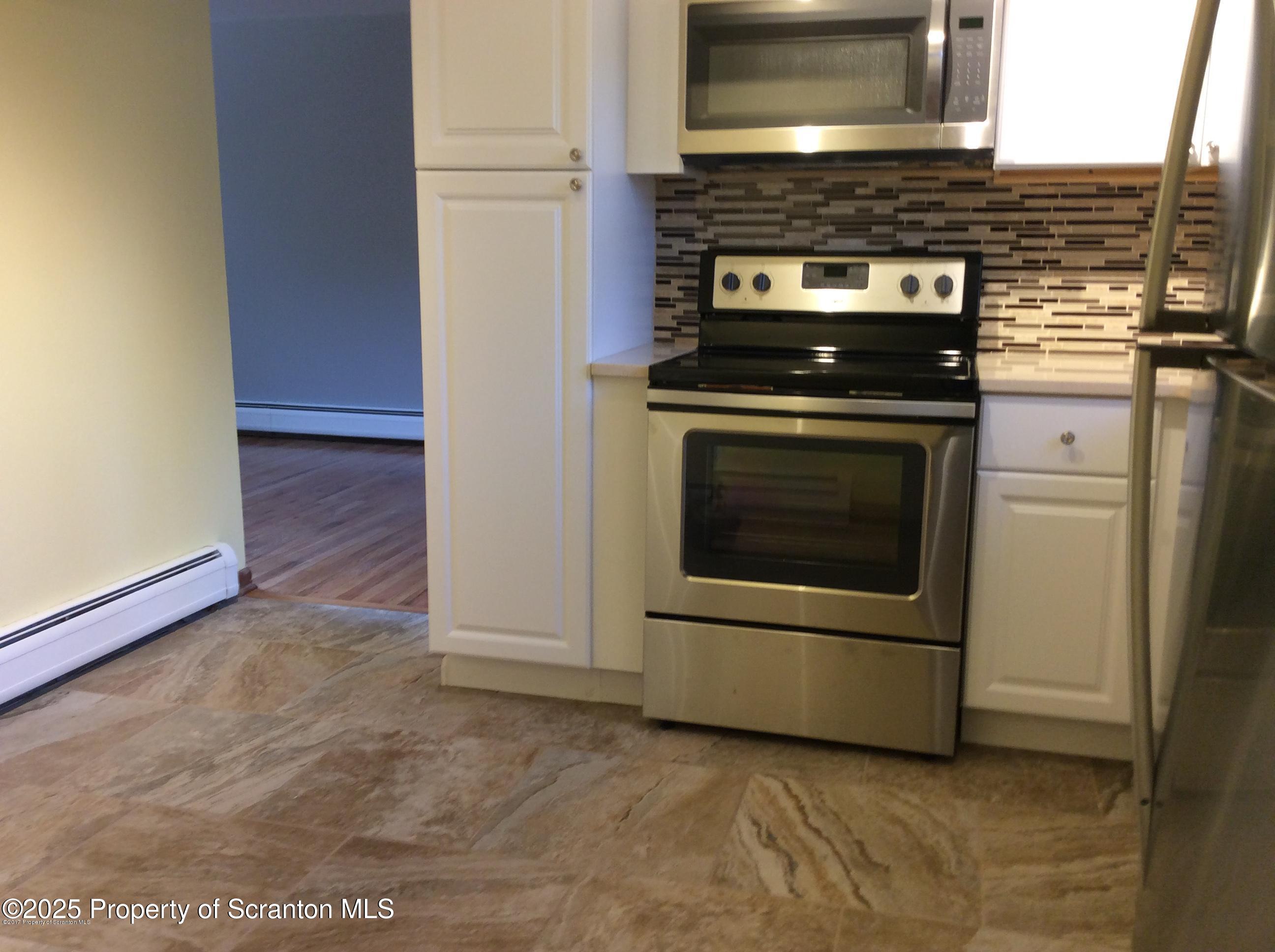 410 /412 Lane Hill Road Tunkhannock, PA 18657 - Photo 6 of 16 a kitchen with granite countertop a stove and a microwave