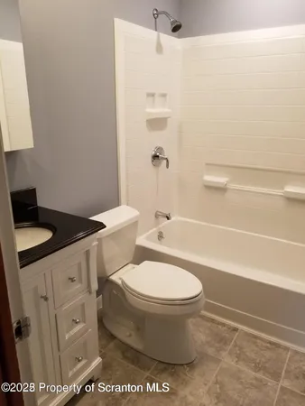 a white toilet sitting next to a bath tub