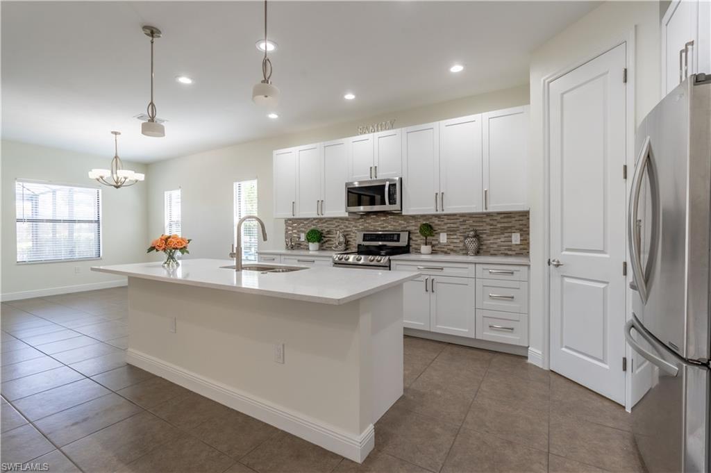 3549 Canopy Circle Naples, FL 34120 - Photo 13 of 50 a kitchen with stainless steel appliances a refrigerator sink and microwave