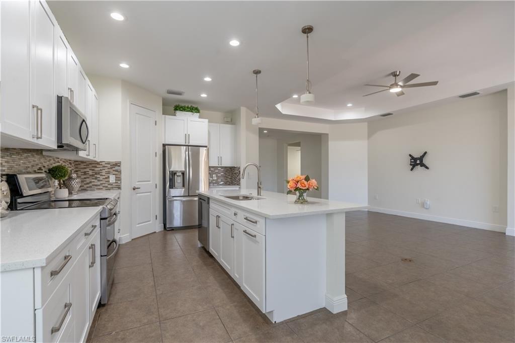 3549 Canopy Circle Naples, FL 34120 - Photo 15 of 50 a kitchen with white cabinets and stainless steel appliances