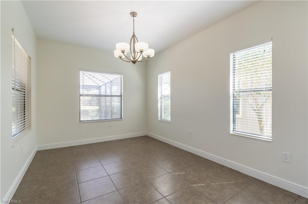 3549 Canopy Circle Naples, FL 34120 - Photo 16 of 50 an empty room with windows and chandelier