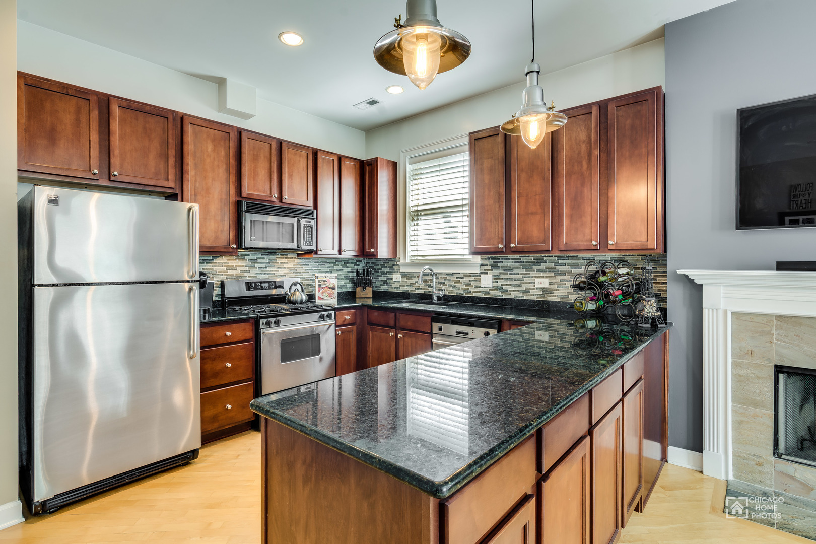 2128 West Walton Street, Unit 2E Chicago, IL 60622 - Photo 7 of 23 a kitchen with stainless steel appliances granite countertop a sink refrigerator and microwave