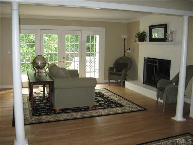 14405 Possum Track Road Raleigh, NC 27614 - Photo 6 of 25 separated from the living room by attractive white columns, the family room has a painted masonry fireplace and a view thru the French doors of the expansive deck and then the lake beyond Den/Family/Great Room