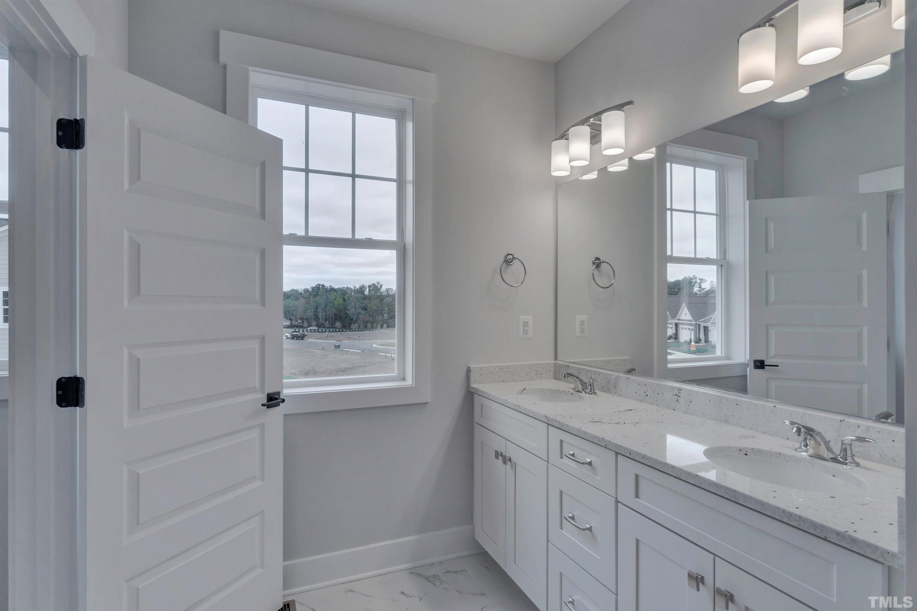 159 Dunloe Loop Raleigh, NC 27603 - Photo 11 of 19 a bathroom with a granite countertop sink a large mirror a vanity and a shower