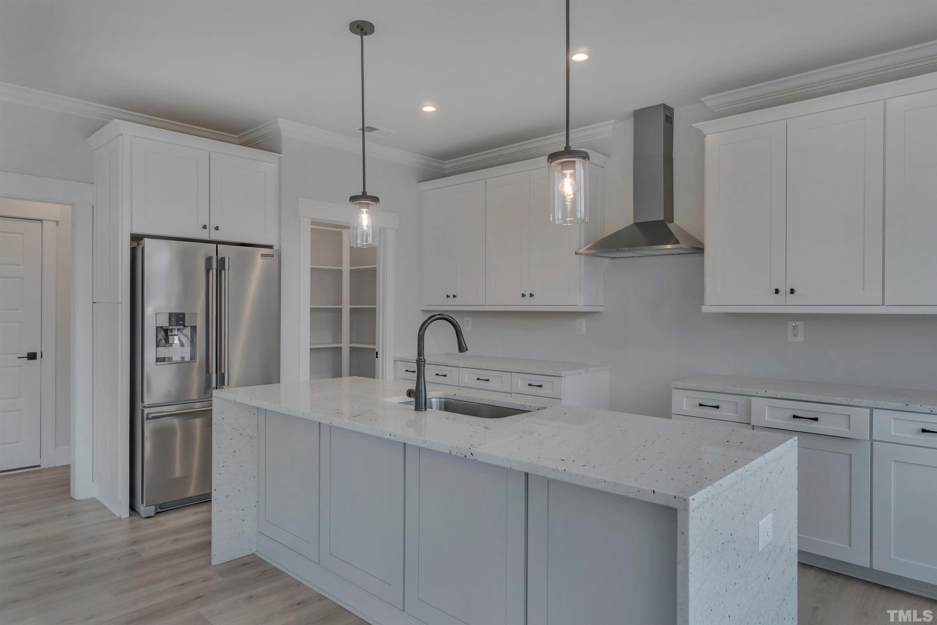 159 Dunloe Loop Raleigh, NC 27603 - Photo 4 of 19 a kitchen with stainless steel appliances a sink a refrigerator a center island and cabinets