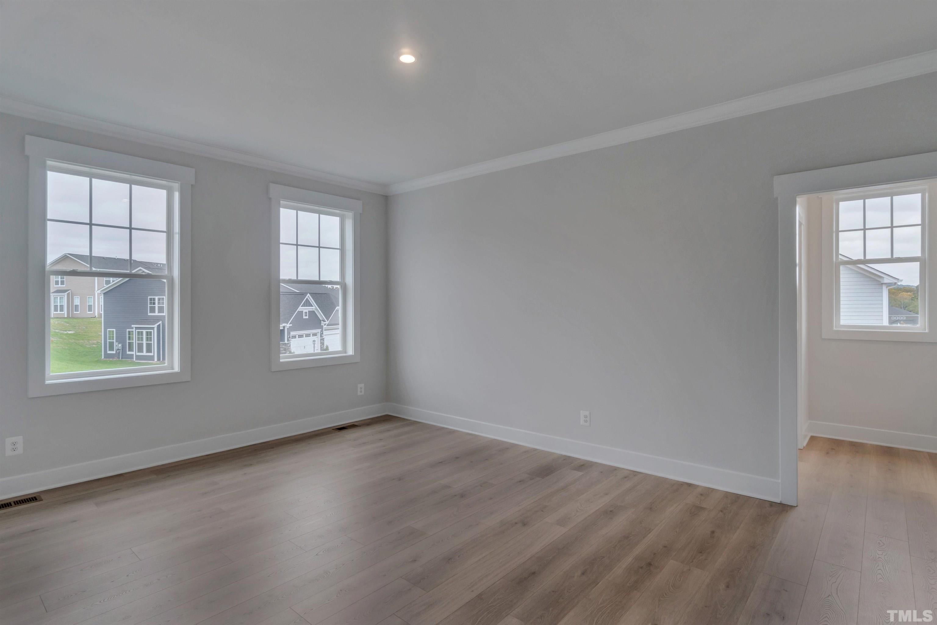159 Dunloe Loop Raleigh, NC 27603 - Photo 6 of 19 an empty room with wooden floor and windows