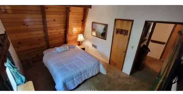 a bedroom with a bed and a flat tv screen