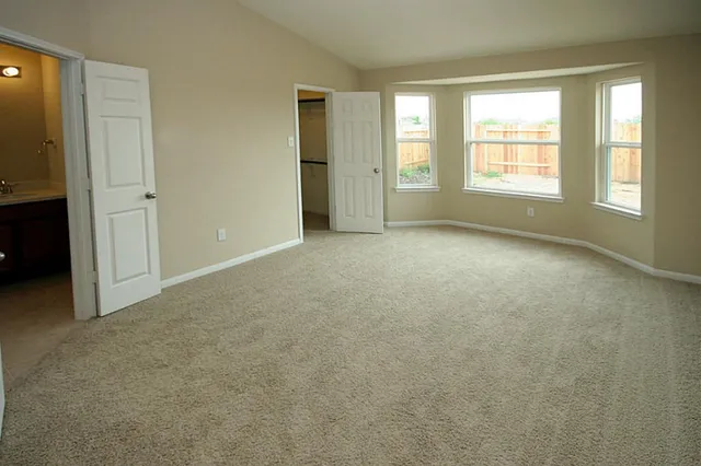 an empty room with windows and closet