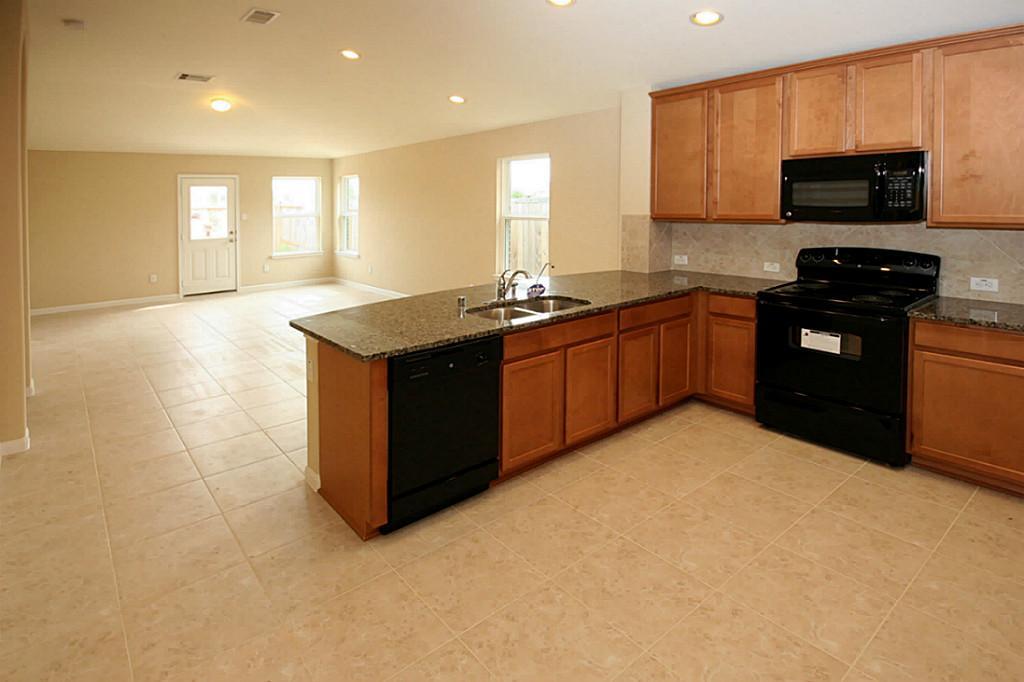 5427 Marble Ravine Richmond, TX 77407 - Photo 2 of 17 a kitchen with stainless steel appliances granite countertop a stove a sink and a refrigerator