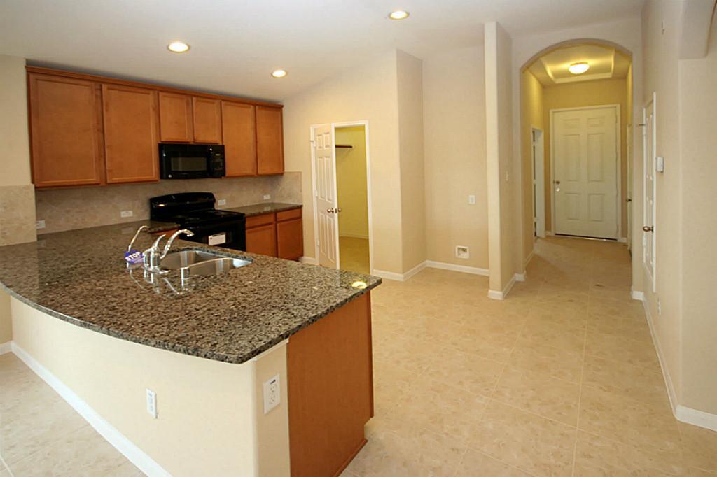 5427 Marble Ravine Richmond, TX 77407 - Photo 3 of 17 a kitchen with kitchen island granite countertop a sink a stove and refrigerator