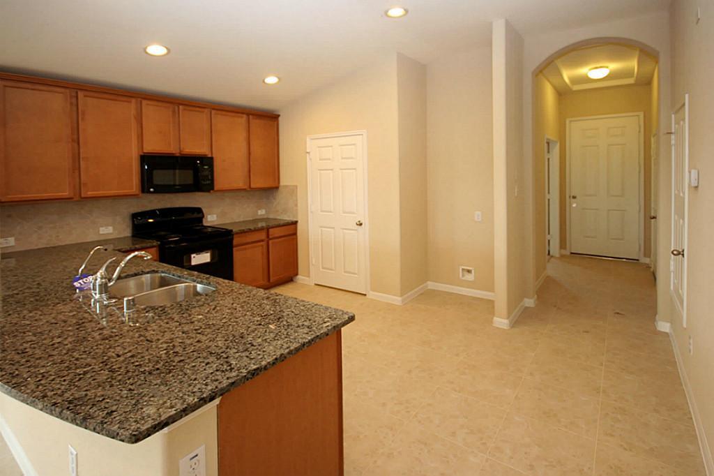 5427 Marble Ravine Richmond, TX 77407 - Photo 4 of 17 a kitchen with a sink refrigerator and microwave