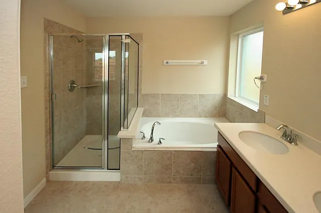 a bathroom with a tub sink shower and mirror