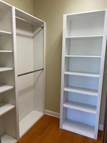 a view of walk in closet with empty racks