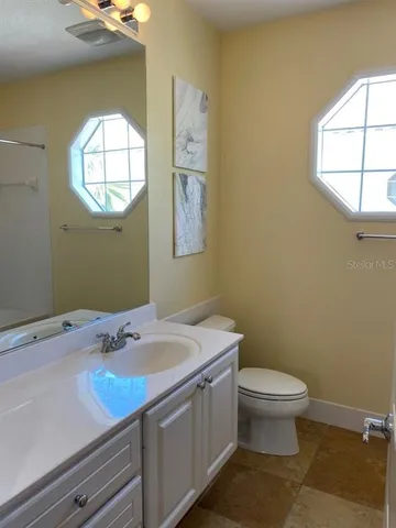 a bathroom with a sink a toilet and window