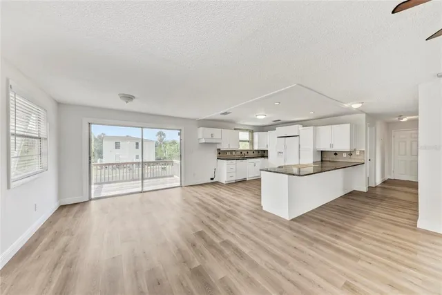 a large white kitchen with wooden floors and white walls