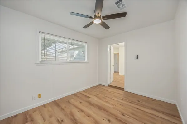 a view of empty room with wooden floor
