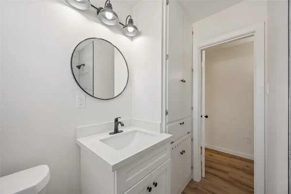 a bathroom with a toilet a sink and a mirror