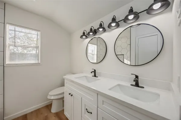 a bathroom with a sink a toilet and a mirror