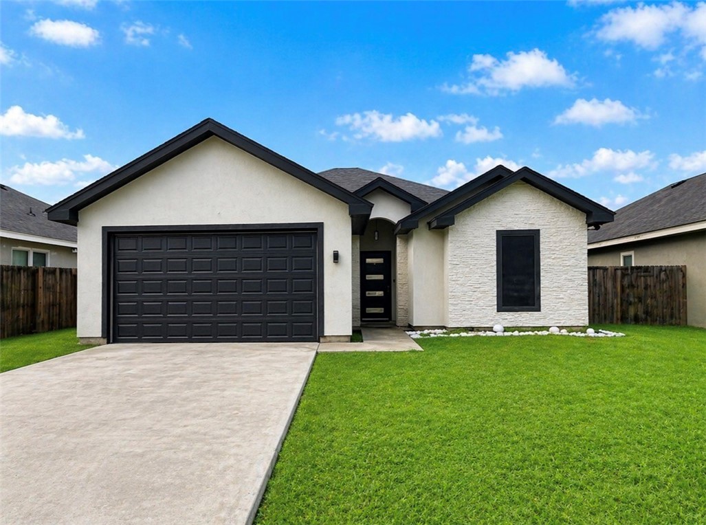 a front view of a house with a yard and garage