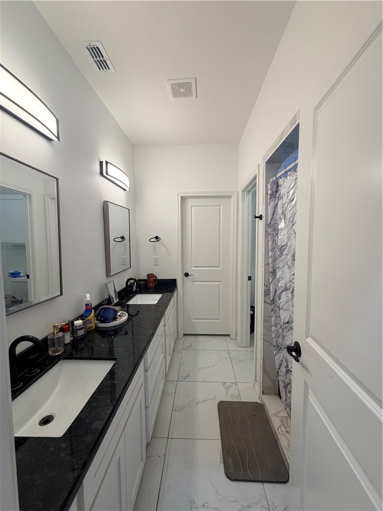 903 West Main Street Alice, TX 78332 - Photo 20 of 24 a bathroom with a double vanity sink and mirror