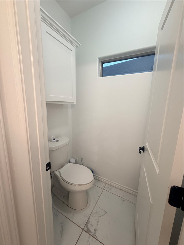 903 West Main Street Alice, TX 78332 - Photo 21 of 24 a white toilet sitting next to a shower