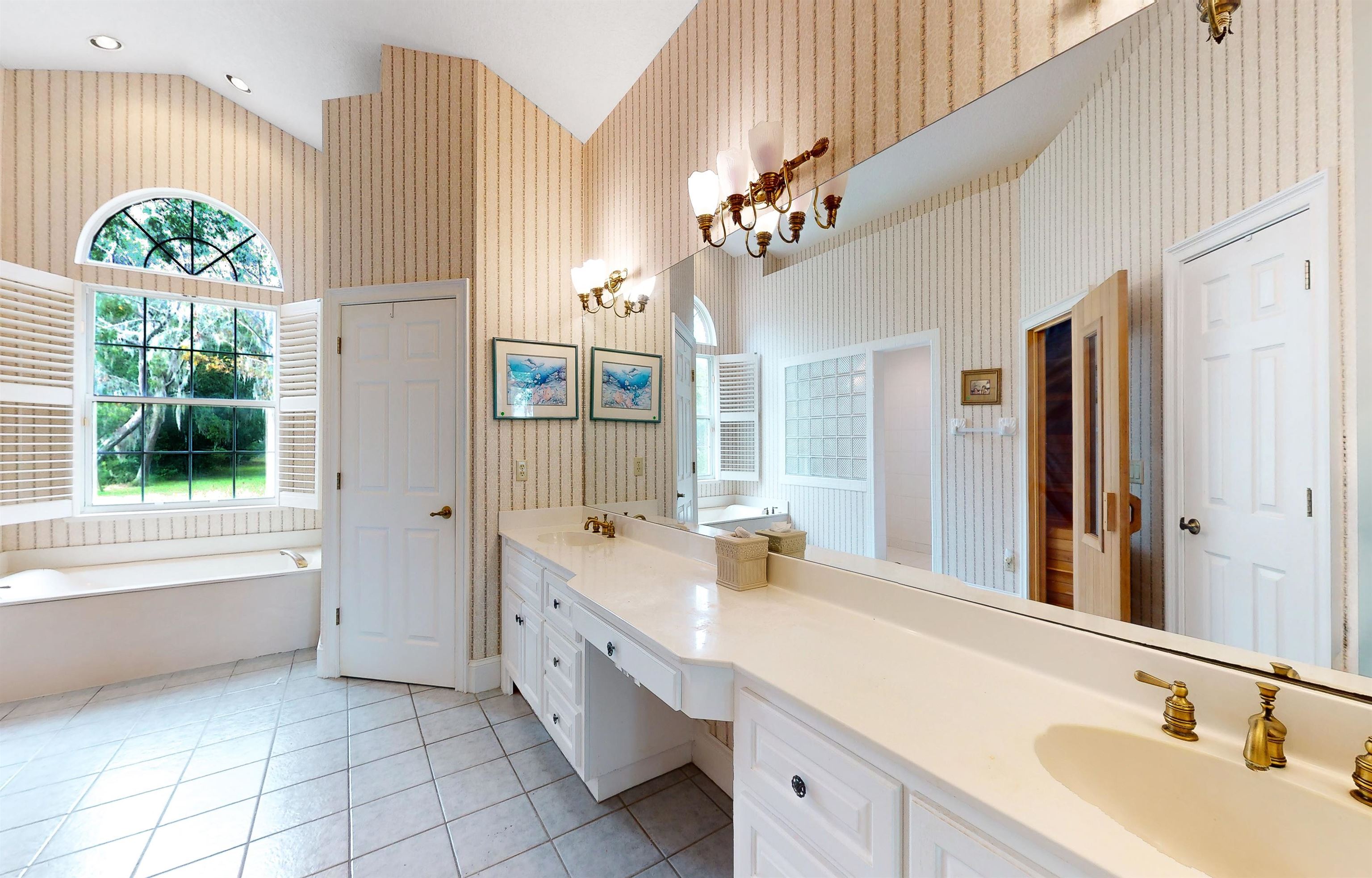 3593 Westover Road Fleming Island, FL 32003 - Photo 29 of 71 a spacious bathroom with a double vanity sink a large mirror a bathtub and window