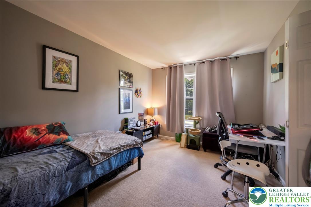 204 Bushkill Ridge Road Wind Gap, PA 18091 - Photo 29 of 48 A quiet bedroom offering comfort and space for rest or productivity, featuring a well-lit desk area and soft carpeting.