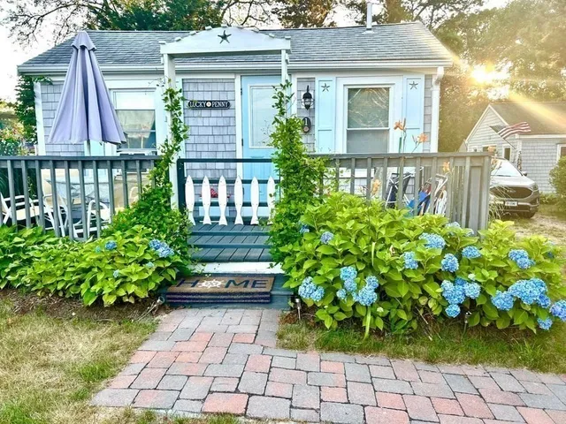 a front view of a house with a lot of flower plants