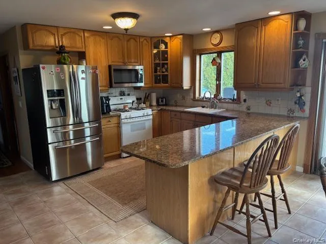 a kitchen with stainless steel appliances granite countertop a stove refrigerator sink and microwave