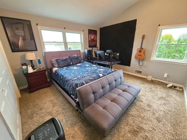 a bedroom with a bed couch and a window