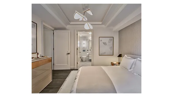 a bedroom with a bed and a chandelier