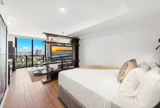 a bedroom with a bed and a flat screen tv