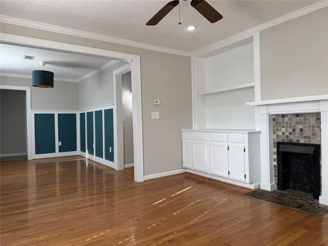 a view of an empty room with a window and a fireplace