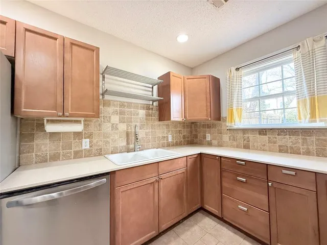 a kitchen with stainless steel appliances a stove a microwave and white cabinets