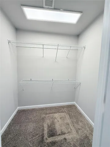 an empty room with ceiling fan and windows