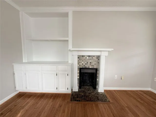 an empty room with windows fireplace and windows