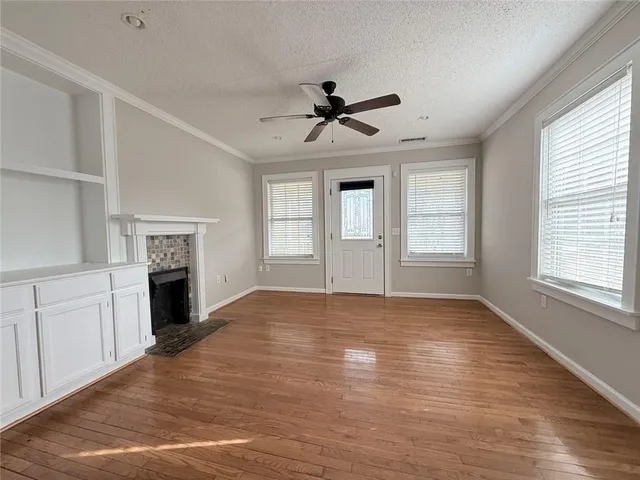an empty room with wooden floor and fireplace